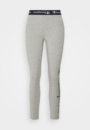 Gray leggings with a black elastic waistband featuring "Champion" logo. Tapered fit with a smooth, stretchy texture. Side logo detail.