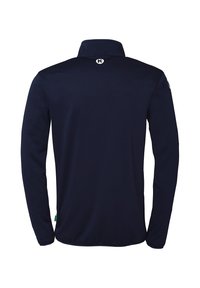 Polo à manches longues navy avec un col montant, une texture lisse, un petit logo au dos du col et une étiquette d'accent vert à l'ourlet.