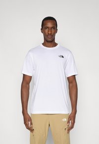 Λευκό βαμβακερό μπλουζάκι με κοντά μανίκια και στρογγυλή λαιμόκοψη, με μικρό μαύρο λογότυπο στο αριστερό στήθος.