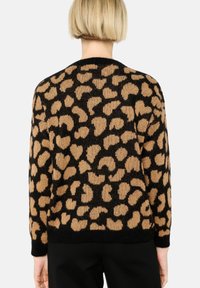 Leopardenmuster-Pullover in Beige und Schwarz, Stricktextur, lange Ärmel, runder Halsausschnitt, lockere Passform und gerippter Saum mit einem Rundum-Muster.