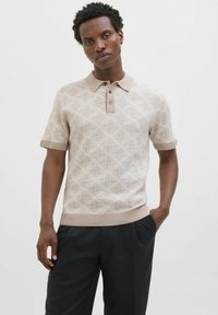 Béžový polo svetr s krátkým rukávem a texturovaným geometrickým vzorem, s límečkem a zapínáním na tři knoflíky.