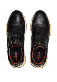 Zapatillas de cuero negro con parte superior texturizada, puntera redonda y cuello acolchado. La suela es de color marrón claro con un acento naranja en el interior.