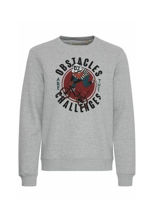 Szürke pulóver hosszú ujjakkal, amelyen egy panda kerékpáron látható grafikai nyomat és a "Az akadályok kihívások" felirat szerepel.