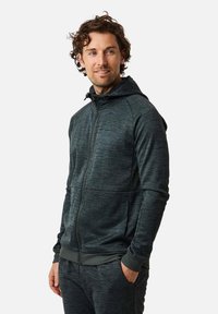 Dark gray zip-up hoodie made of textured fabric with a hood, featuring front pockets and ribbed cuffs and hem.