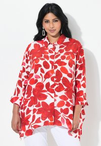 Chemise à imprimé floral rouge avec un col, boutonnage à l'avant et manches trois-quarts. Tissu doux avec une coupe ample et décontractée.