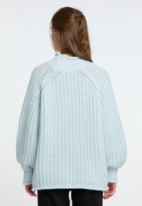 Light blue knitted sweater with a high collar, textured pattern, dropped shoulders, and slightly oversized fit. Ribbed cuffs and hem.