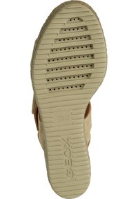 Suela de zapato Geox beige con una superficie texturizada, que presenta filas de agujeros de ventilación y la marca. Suela con un patrón para agarre.
