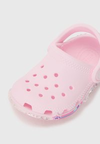 Pink molded clog with ventilation holes, semi-transparent sole, and a colorful accent. Made of soft, lightweight material.