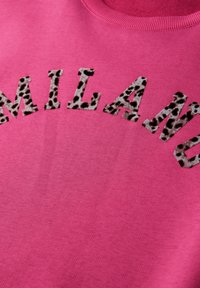 Rosa Sweatshirt mit dem Wort "MILANO" in Leopardenmuster-Stoff. Das Material ist strukturiert und das Design verfügt über einen klassischen Rundhalsausschnitt.
