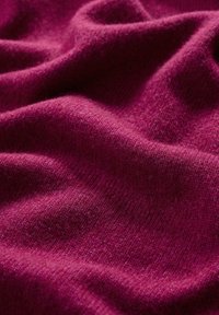 Kruvino raštuoto audinio su švelniu, tekstūruotu paviršiumi, turinčiu subtilių atspalvių ir gylio variacijų, sudėtų švelniuose raukšlėse.