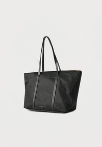 Μαύρη τσάντα tote από νάιλον, με δύο μακριές λαβές, κάθετες ραφές και λεπτομέρεια με φερμουάρ σε χρυσό τόνο.