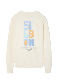 Sudadera color crema con un diseño geométrico en azul, amarillo y naranja. El texto dice "DISEÑO GEOMÉTRICO PARA UNA VIDA ORGÁNICA."