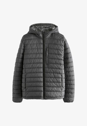 Homme portant une veste noire matelassée à fermeture éclair avec capuche et un polo bordeaux, les mains dans les poches de la veste.