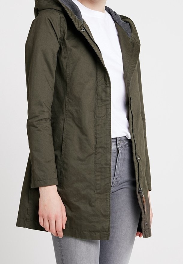 Chaqueta verde oliva con capucha, cremallera frontal, tejido texturizado y forro gris. Presenta un diseño ajustado con mangas largas y bolsillos laterales.