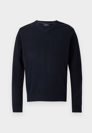 Sweater azul marinho em V feito de um tecido macio, com mangas longas e bainha canelada. Design minimalista com um rótulo simples na gola.