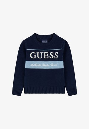 Pull en tricot bleu marine avec un col rond, orné de rayures blanches et bleu clair et du texte "GUESS" et "Authentic Denim Brand."