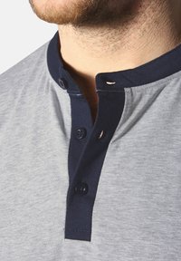 Gray cotton polo shirt featuring a navy collar, button placket, and short sleeves. The fabric has a subtle texture.