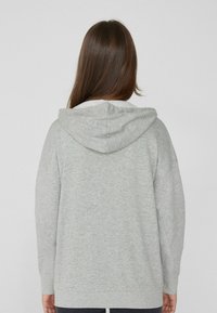 Grauer Hoodie mit weicher Textur, ausgestattet mit einer runden Kordelzugkapuze, langen Ärmeln und einem lockeren Schnitt. Minimalistisches Design ohne sichtbare Muster.