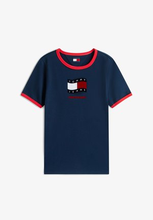 Camiseta de manga corta azul marino con ribete rojo en el cuello y las mangas, con un logotipo de Tommy Jeans y el texto "¡Orgulloso de ser Jeans!".