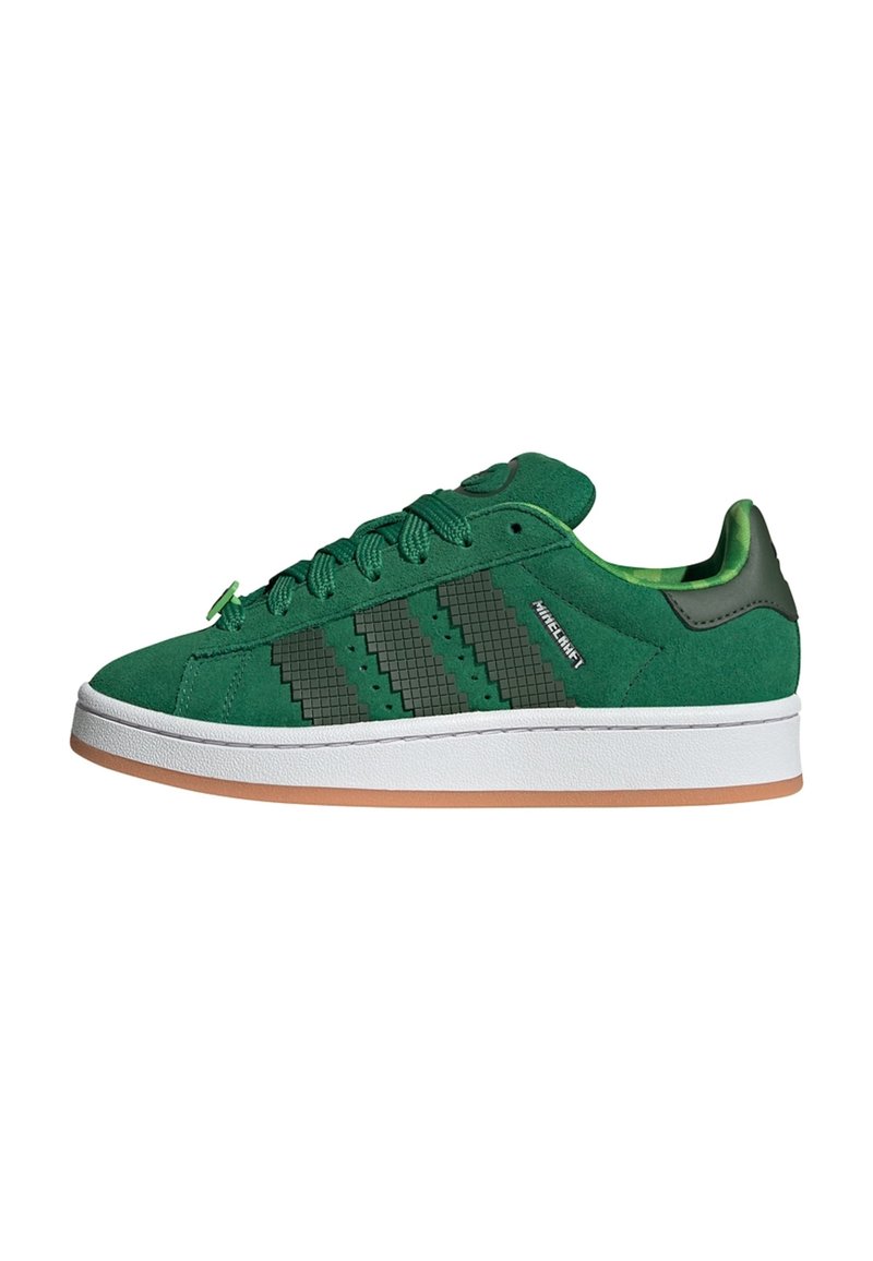 Zapatillas de ante verde con tres rayas en forma de chevron de color verde oscuro, una suela de goma blanca y un acento texturizado en el talón.