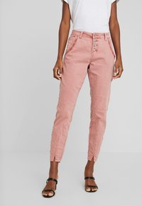 Rosa bomullsmixbyxor med hög midja, femknappsstängning, sidofickor och ventilerade fållar, med en slät, lätt rynkad textur.