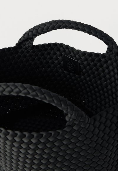 Μαύρο υφαντό καλάθι αποθήκευσης με δύο στρογγυλές λαβές. Διαθέτει υφή στην επιφάνεια και μικρό λογότυπο στην εσωτερική πλευρά.