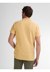 Geel polo shirt met een klassieke kraag, korte mouwen en een rechte zomen. Gemaakt van katoen, met een zachte textuur.