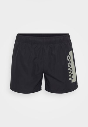 Costumini da bagno neri con elastico in vita e logo grigio "HUGO" stampato sul lato sinistro. Tessuto leggero e liscio, design fino al ginocchio.