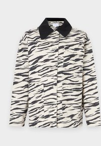 Ζακέτα με μοτίβο ζέβρας σε μπεζ και μαύρο, κατασκευασμένη από ύφασμα με γιακά, δύο εμπρόσθιες τσέπες και κλείσιμο με κουμπιά.