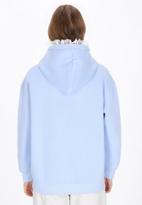 Hellblauer Hoodie aus weichem Stoff, mit einer Kapuze und einem strukturierten weißen Spitzenbesatz am Ausschnitt. Schlichte Form und lockere Passform.