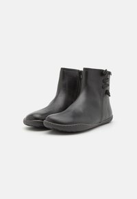 Black leather ankle boots with a smooth texture, rounded toes, side zippers, and decorative lacing accents at the heel.