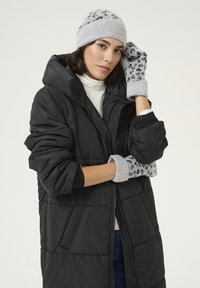 Giacca a vento nera con cappuccio, berretto grigio lavorato a maglia con stampa leopardata e guanti grigi. Morbida texture e vestibilità casual.