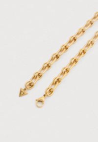 Κολιέ αλυσίδα από χρυσό μέταλλο με οβάλ κρίκους, μενταγιόν σε σχήμα τριγώνου με λογότυπο και κούμπωμα τύπου αστακού. Λείο υφή με γυαλιστερό φινίρισμα.