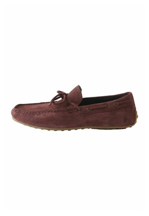 Men’s brown suede moccasin loafer with lace detail, stitched toe, and rubber sole, shown from the side.