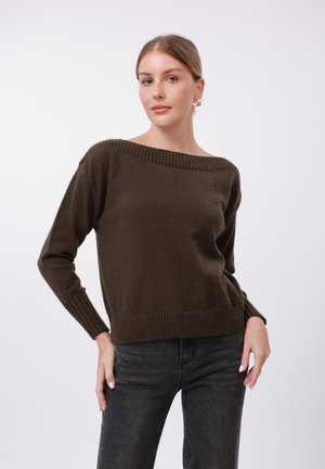 Mørkebrun strikket genser med bred, ribbestrikket halslinning og lange ermer. Teksturen ser myk ut med en avslappet passform, kombinert med svarte jeans.
