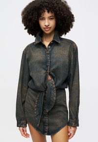 Rochie din denim cu nasturi la front, mâneci lungi, detaliu la talie legat, de culoare albastră închisă, estompată, cu cusături contrastante.