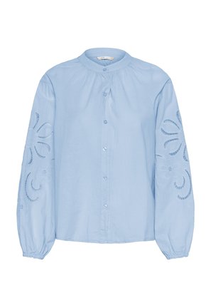 Blusa leggera azzurro chiaro a maniche lunghe con colletto rotondo, presenta dettagli ricamati sulle maniche e chiusura frontale con bottoni.