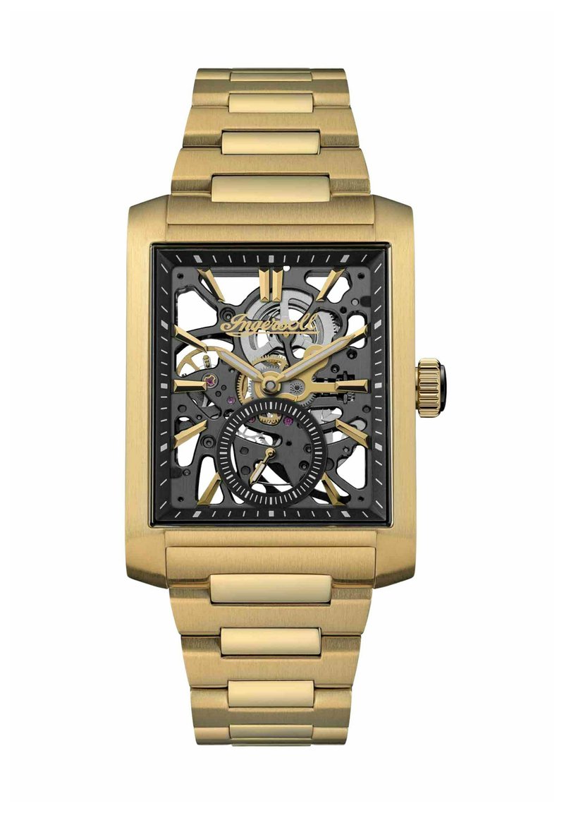 Złoty prostokątny szkieletowy zegarek z czarną tarczą, widocznymi mechanizmami i czarnymi akcentami. Metalowa bransoleta o połączonej konstrukcji i teksturowanej powierzchni.