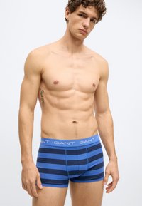 Modro-mornarsko modre bokser hlačke z GANT logotipom na pasu, z gladkim, oprijetim dizajnom in bombažnim materialom.