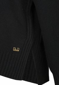 Schwarzer Strickpullover mit strukturiertem Rippmuster, versehen mit einem goldenen Logo-Tag, auf dem "1969" am Saum steht. Seitenschlitze für eine bequeme Passform.