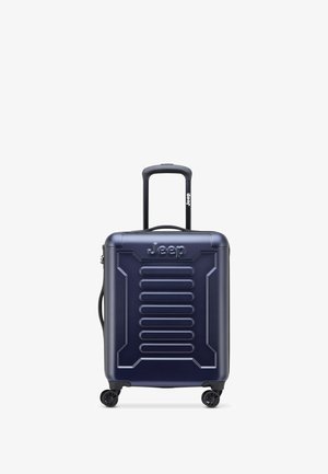 Valigia rigida blu navy con scanalature verticali, logo Jeep, manico telescopico e quattro ruote girevoli nere per una facile manovrabilità.