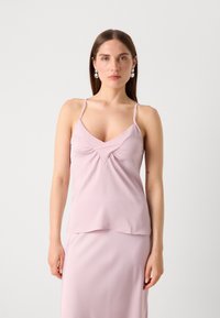 Lyserød satin camisole med tynde stropper, der har en V-udskæring og samlet detaljering i midten. Glat tekstur, flydende design.