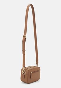 Malá obdélníková hnědá kožená crossbody taška s nastavitelným popruhem a zlatými zipy na bílém pozadí.