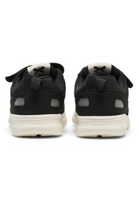 Zapatillas deportivas negras con parte superior de tejido texturizado, suela de goma blanca y cuello acolchado, que cuentan con una tira de agarre y detalles reflectantes.