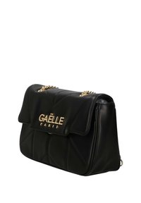 Borsa a tracolla in ecopelle nera trapuntata con dettagli in oro, dotata di chiusura a patta e logo "GAËLLE PARIS" impresso. Inclusa una tracolla a catena.