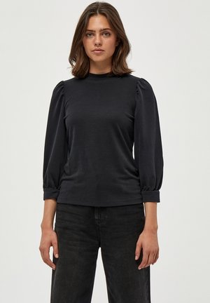 Schwarzes Langarmshirt mit gepufften Schultern, figurbetontem Schnitt und Rundhalsausschnitt. Weicher Stoff mit glatter Textur und umgeschlagenen Bündchen.