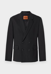Black double-breasted blazer with notched lapels, front pockets, and buttons. Fabric appears smooth with a slight sheen. HUGO label visible inside.