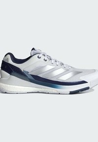 Ανδρικά αθλητικά παπούτσια με λευκό διχτυωτό επάνω μέρος, ναυτικές λεπτομέρειες και ασημένιες ρίγες. Διαθέτουν υφή στη σόλα και μαξιλάρι στη φτέρνα για στήριξη.