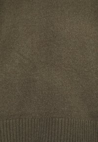 Olivově zelený svetr vyrobený z měkké texturované pleteniny; má žebrovaný lem pro dodatečný detail.