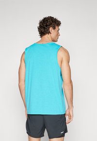 Light blue sleeveless tank top made of soft fabric, featuring a round neck and a relaxed fit, shown from the back with a smooth texture.